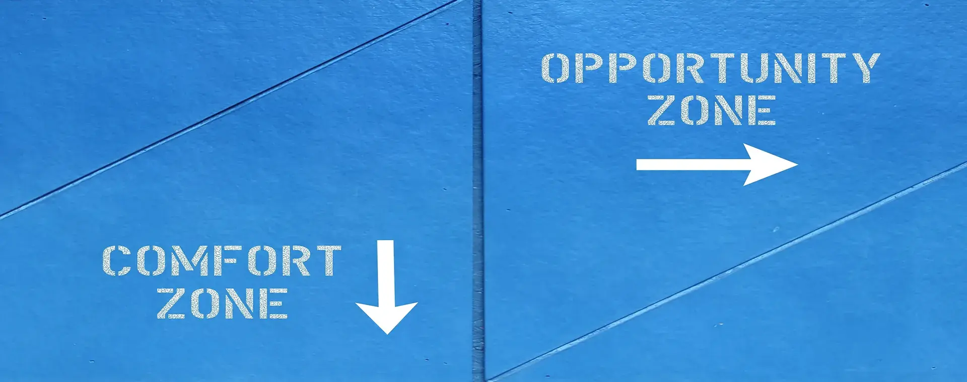 Blue painted pavement stencilled "Comfort Zone" with an arrow pointing down and "Opportunity Zone" with an arrow pointing right.
